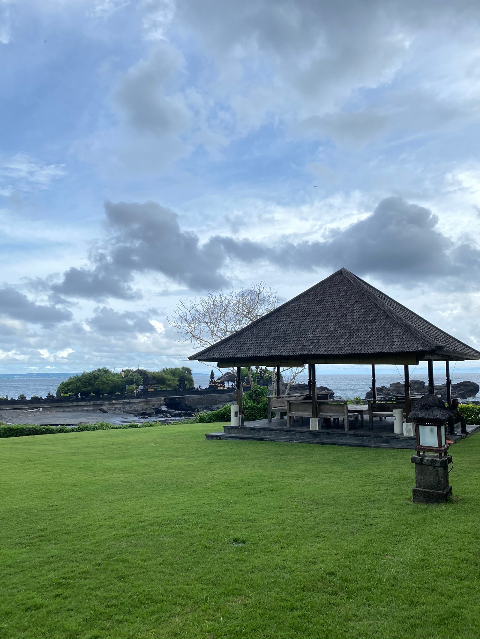 Há um gazebo no meio de um campo gramado (bali, nuvem, imóveis, grama, planície)