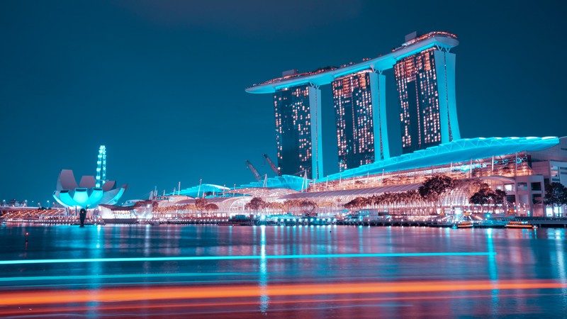 Вид на городской силуэт ночью с лодкой в воде (марина бей сэндс, marina bay sands, отель, сингапур, синий час)