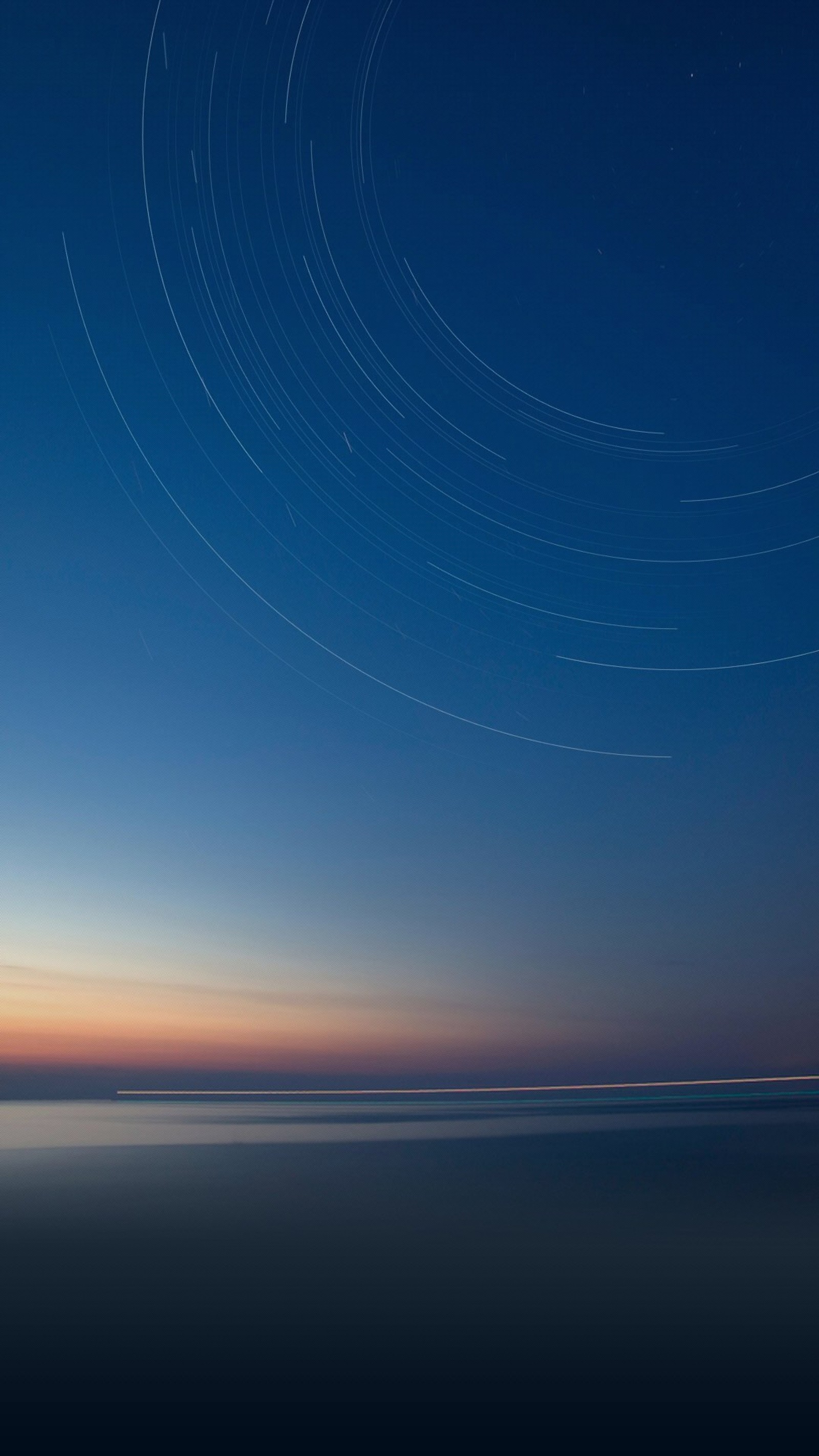 Vue aérienne d'une plage avec une traînée d'étoiles dans le ciel (smartphone, android, bleu, horizon, atmosphère)