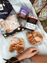 Verschiedene Croissants und Aufstriche auf einer Picknickdecke