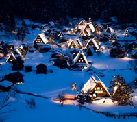 Aldea cubierta de nieve iluminada por la noche