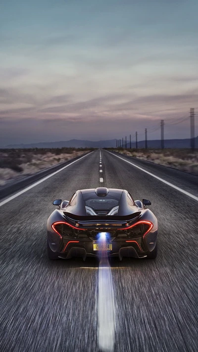 McLaren P1 acelerando em uma estrada aberta ao anoitecer