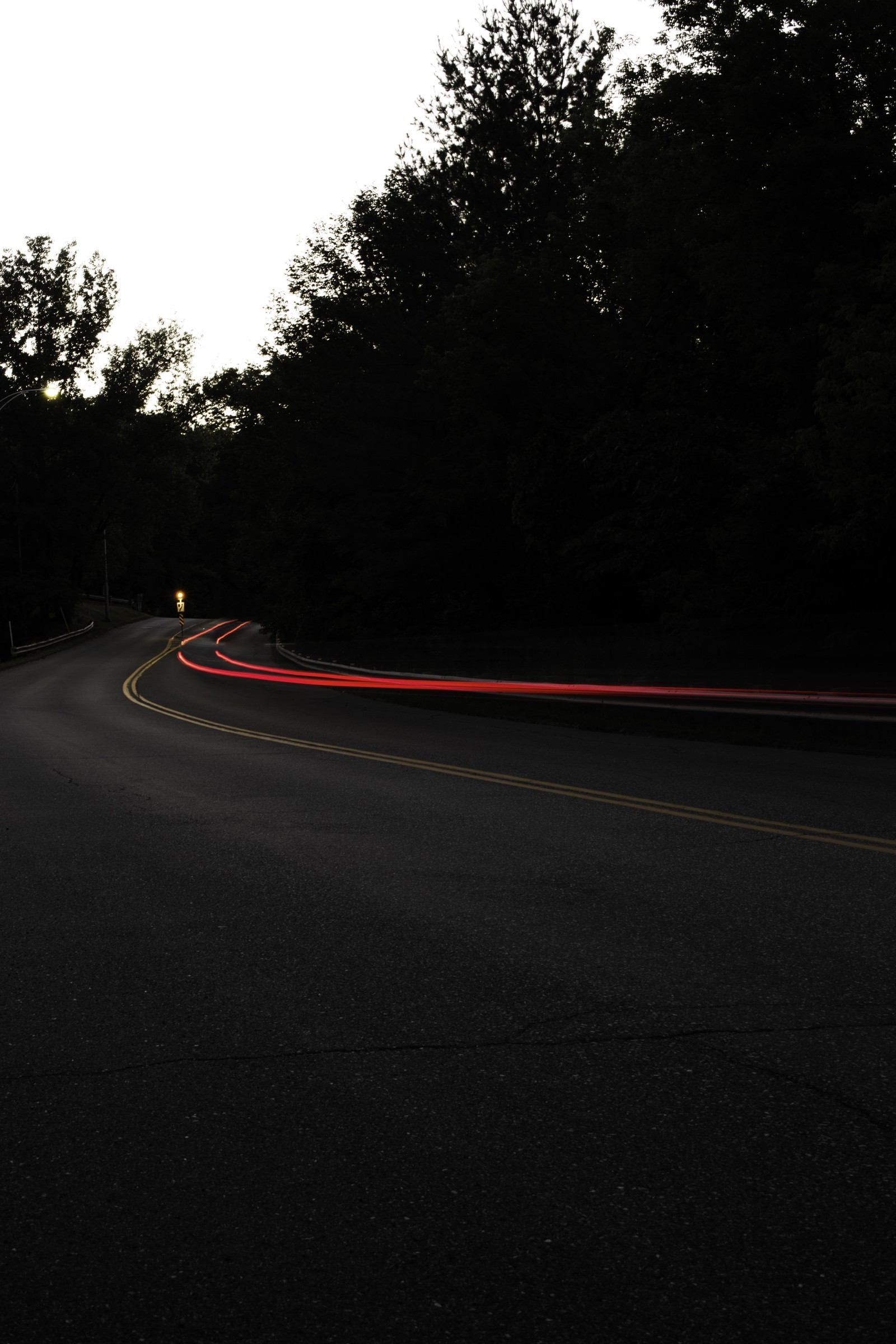 Hay un coche conduciendo por la carretera de noche (hormigón asfáltico, hormigón, negro, camino, asfalto)