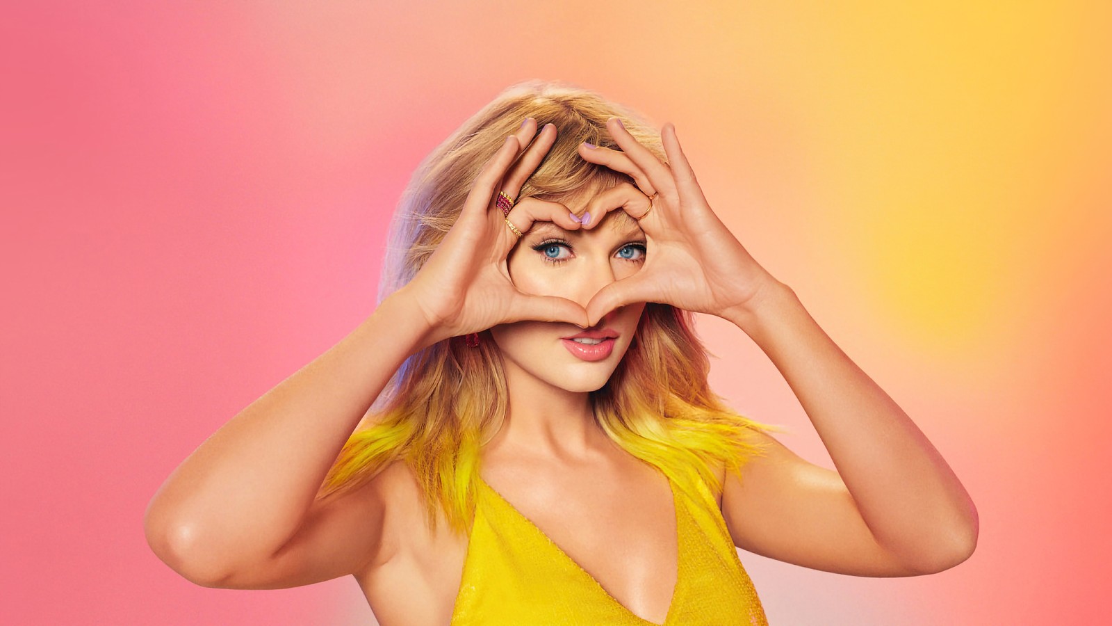 A woman in a yellow dress making a heart with her hands (taylor swift, singer, celebrity, women, girls)