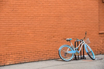 Bicicleta estacionada contra uma parede de tijolos laranja