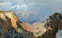 Vista majestosa do Grand Canyon com cobertura de nuvens dramáticas e terreno acidentado.