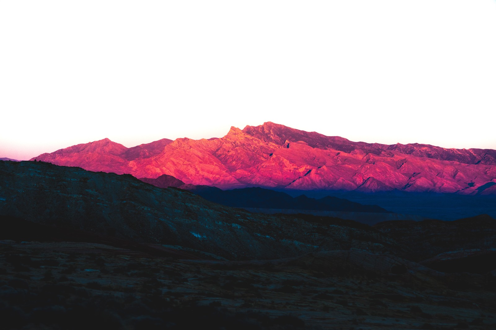 Une vue d'une chaîne de montagnes avec un coucher de soleil en arrière-plan (purple mountains, nevada, montagnes rocheuses, ombre, ensoleillement)