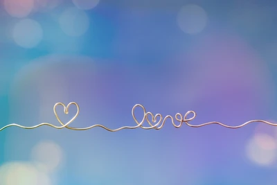 Coração de amor elegante com letras douradas em um fundo bokeh