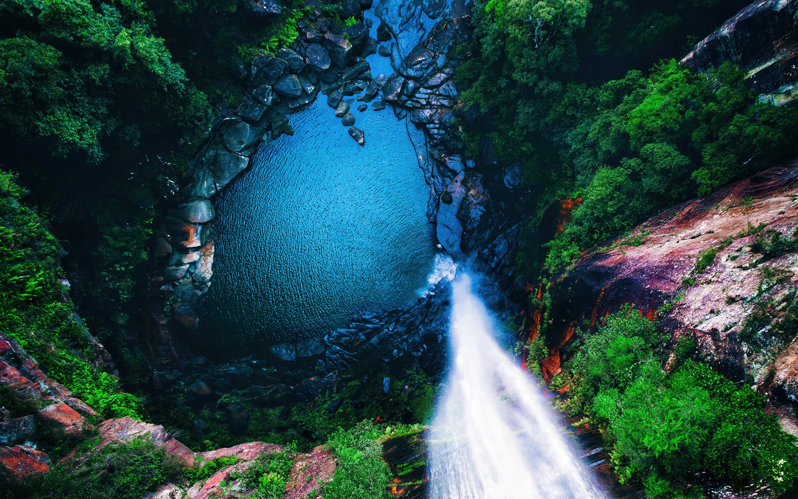 Uma vista de uma cachoeira descendo um lado da montanha ao lado de uma floresta verde e exuberante (cachoeira, visão aérea, floresta, 5k, natureza)