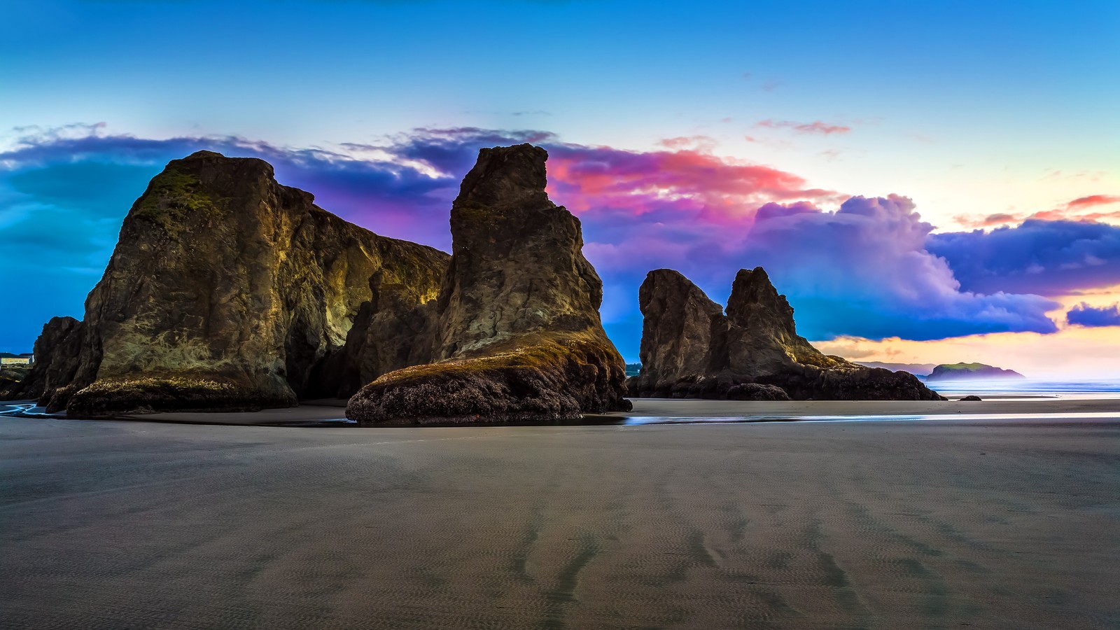 Uma vista de uma praia com pedras e um pôr do sol ao fundo (nuvem, atmosfera, água, montanha, paisagem natural)