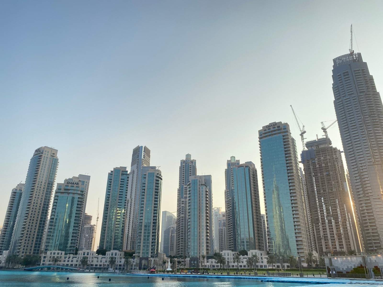 Edificios en el fondo de una ciudad con un cuerpo de agua (dubái, dubai, rascacielos, agua, bloque de torre)