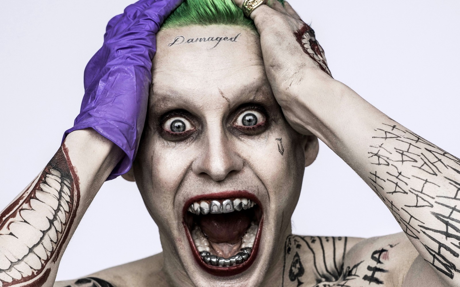 A close up of a person with tattoos and a green hair (joker, suicide squad, harley quinn, dc comics, head)