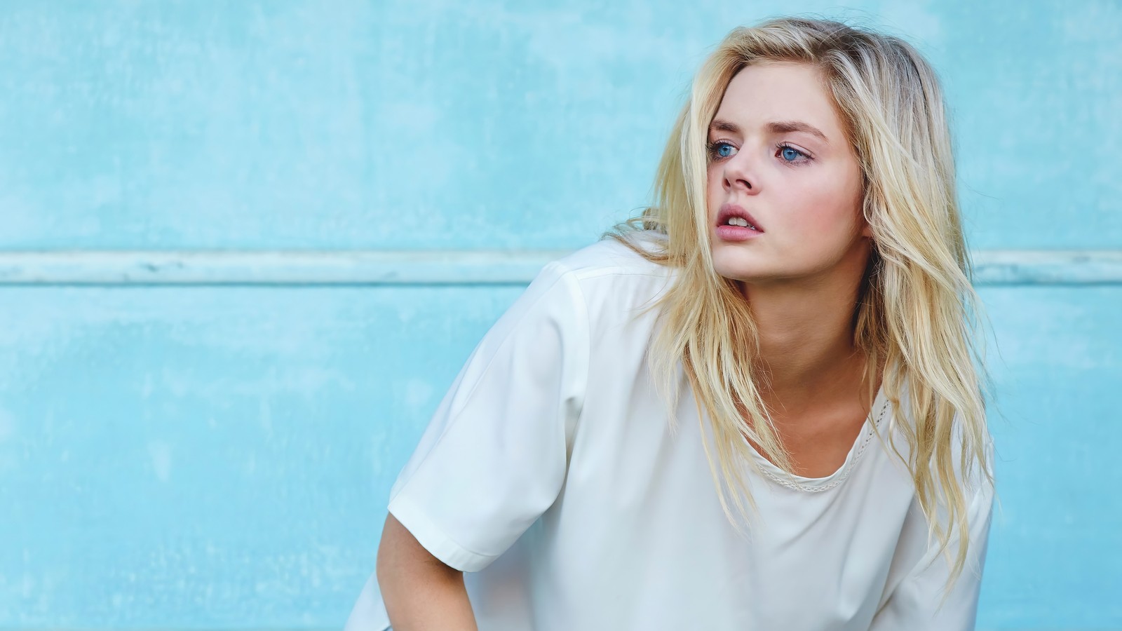 Arafed blonde assise sur un mur bleu avec une raquette de tennis (tissage de samara, australien, actrice, célébrité, femmes)