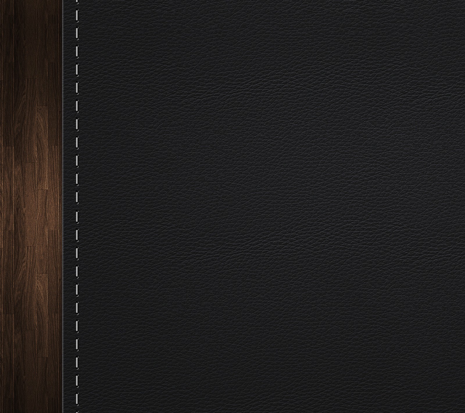 A close up of a black leather surface with a wooden background (dark, leather, wood)