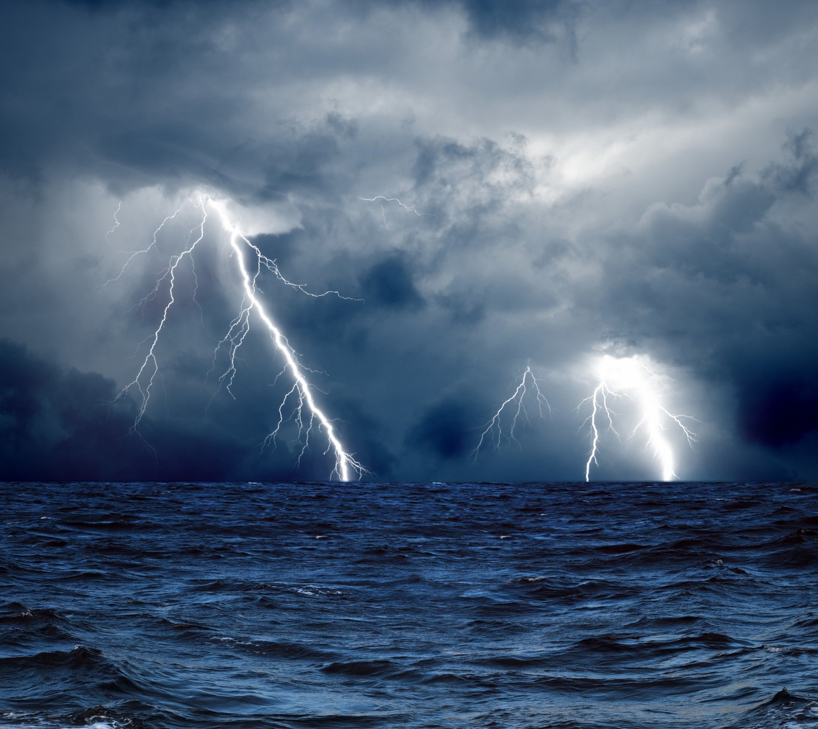 Lightning strikes over the ocean during a storm in the sky (hd, sea, storm)