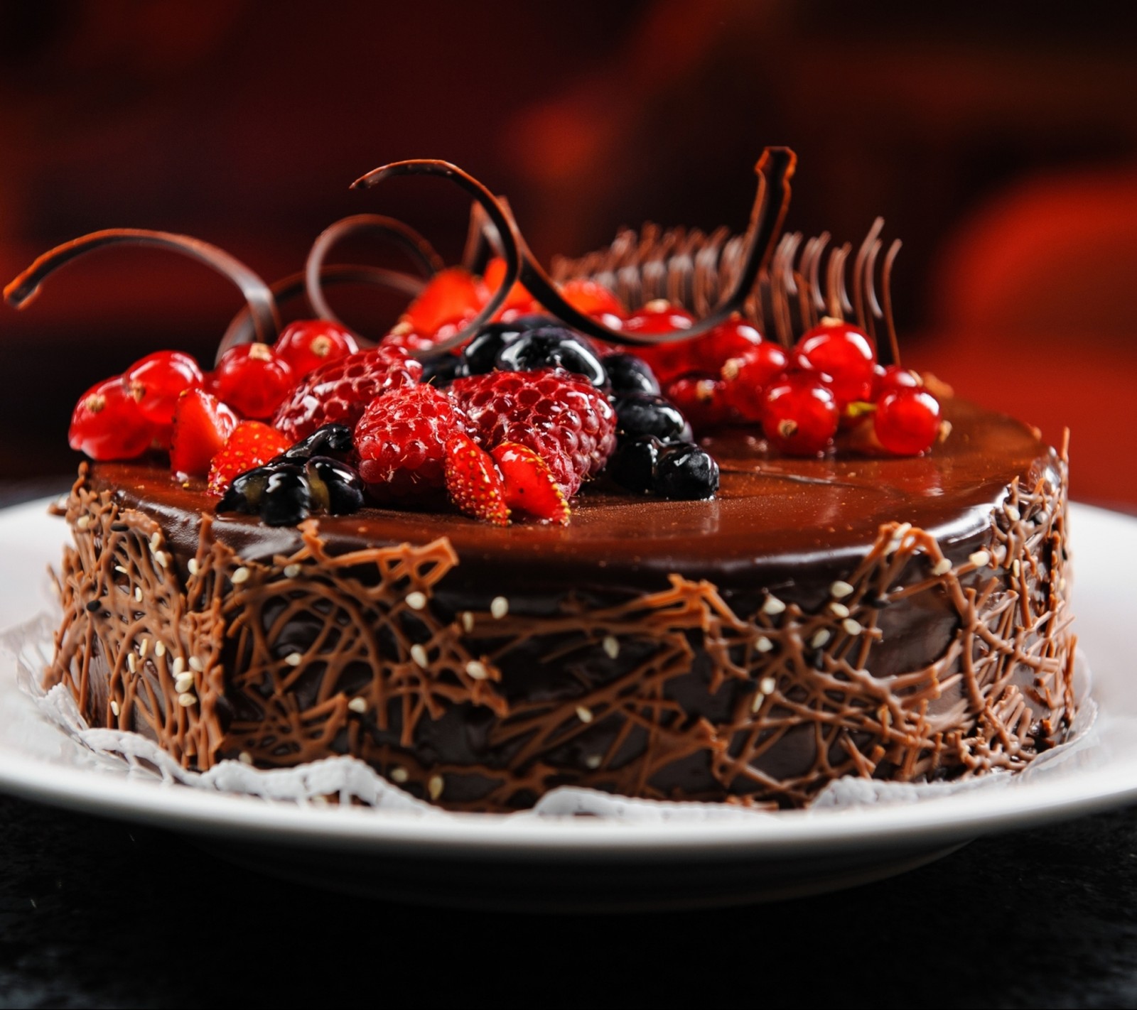 Hay un pastel de chocolate con bayas en un plato (cumpleaños, cacke, feliz)