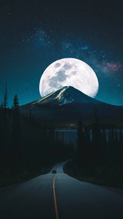 Lever de lune majestueux sur un paysage montagneux serein.