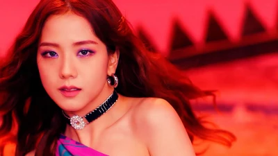 Jisoo of BLACKPINK radiates elegance and charisma in vibrant, colorful attire.