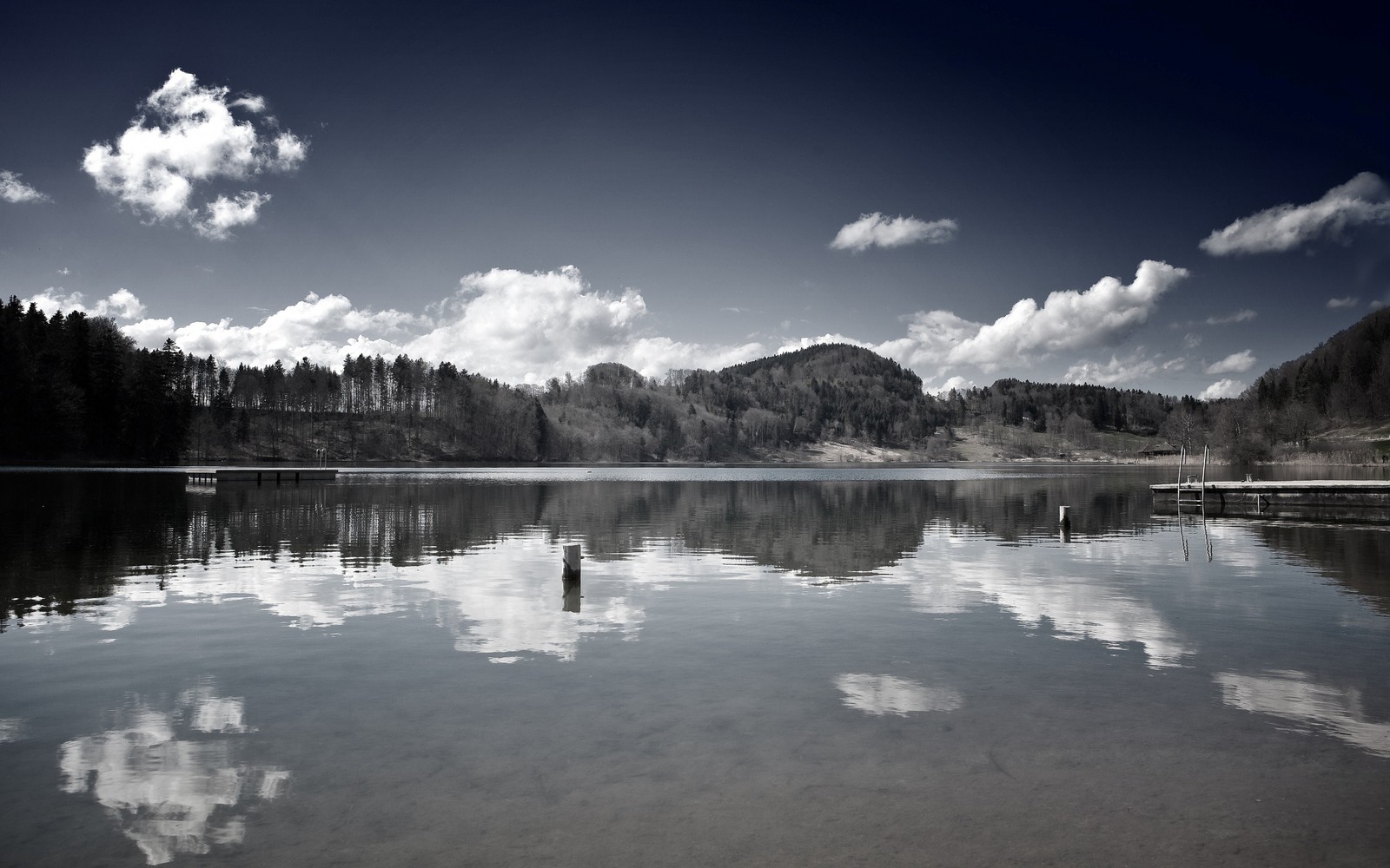 There is a lake with a dock and a mountain in the background (reflection, body of water, nature, water, cloud)