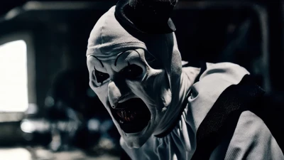 Art el Payaso muestra amenazadoramente su aterradora sonrisa en un entorno oscuro y atmosférico de "Terrifier 3".