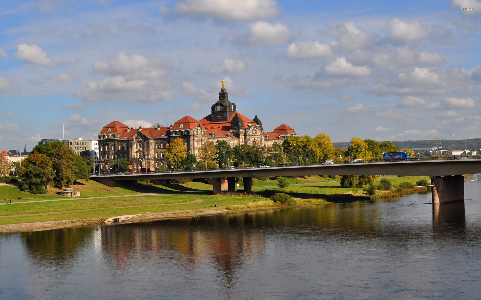 Eine brücke über einen fluss mit einem gebäude im hintergrund (dresden, fluss, reflexion, brücke, bank)