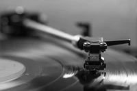 Gros plan d'une aiguille de phonographe sur un disque vinyle monochrome