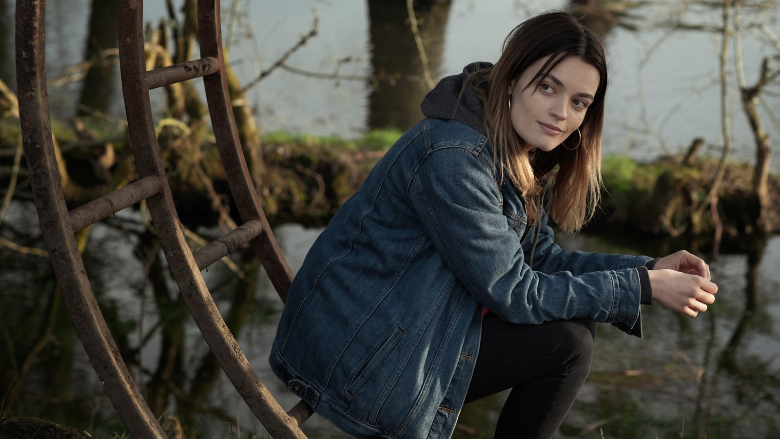 Femme girafe assise sur une branche d'arbre dans une forêt (emma mackey, actrice, célébrité, femmes, filles)