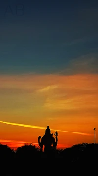 Silueta del Señor Shiva contra un vibrante cielo de atardecer