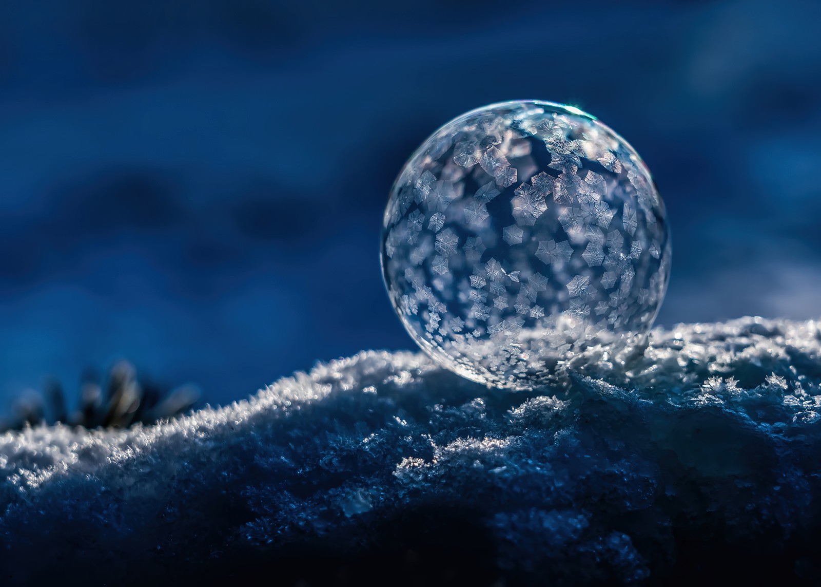 A close up of a crystal ball on a snowy surface (frozen bubble, winter snow, soap bubble, macro, photography)