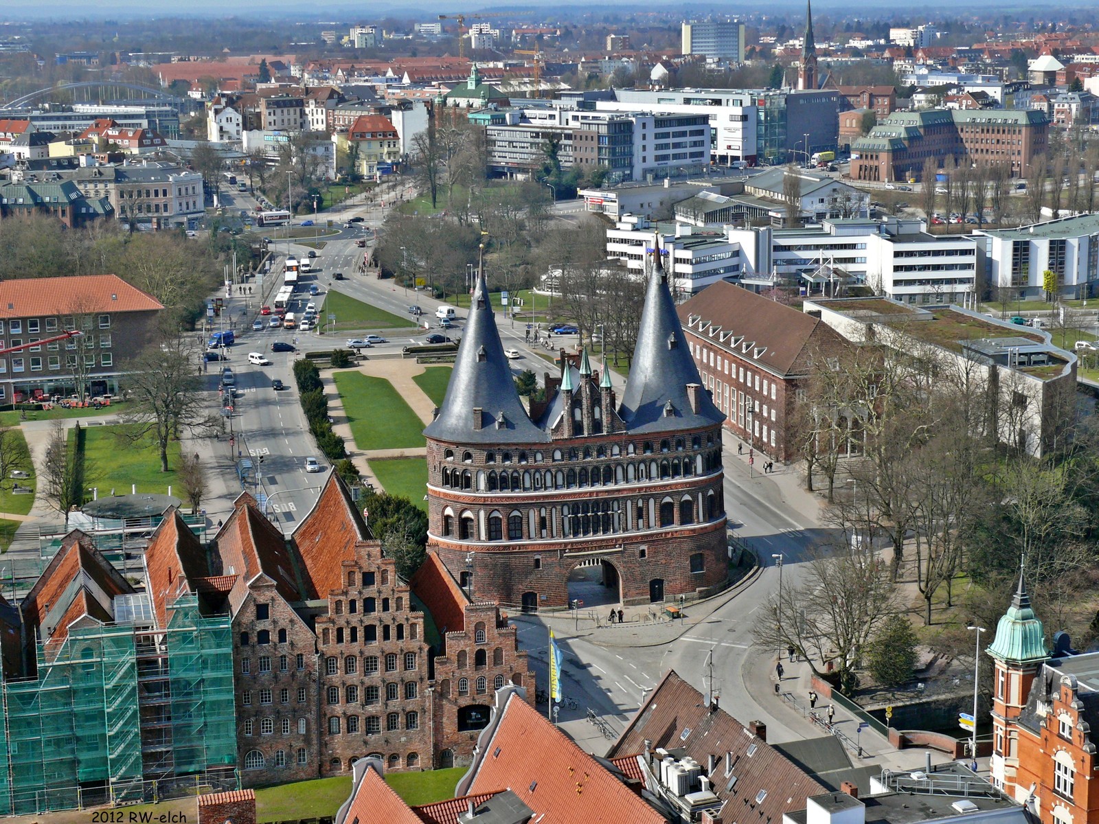 Une vue fortifiée d'une ville avec une tour de l'horloge et une pelouse verte (zone urbaine, ville, paysage urbain, bâtiment, place)