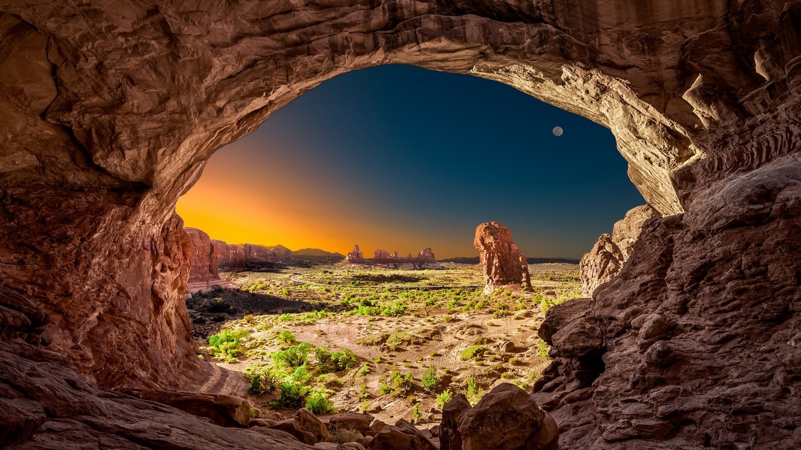 Una vista de un paisaje desértico desde dentro de una cueva (parque nacional, parque, arco, arco natural, formación)