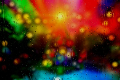 Fondo bokeh multicolor con gotas de lluvia en la ventana