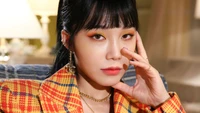 Jung Eun-ji of Apink exudes confidence in a vibrant plaid ensemble, showcasing her striking makeup and captivating gaze.