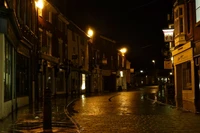 Nuit pluvieuse dans une ruelle urbaine : reflets des lampadaires