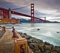 Pont du Golden Gate à San Francisco, États-Unis, avec un ciel dramatique et des eaux calmes.