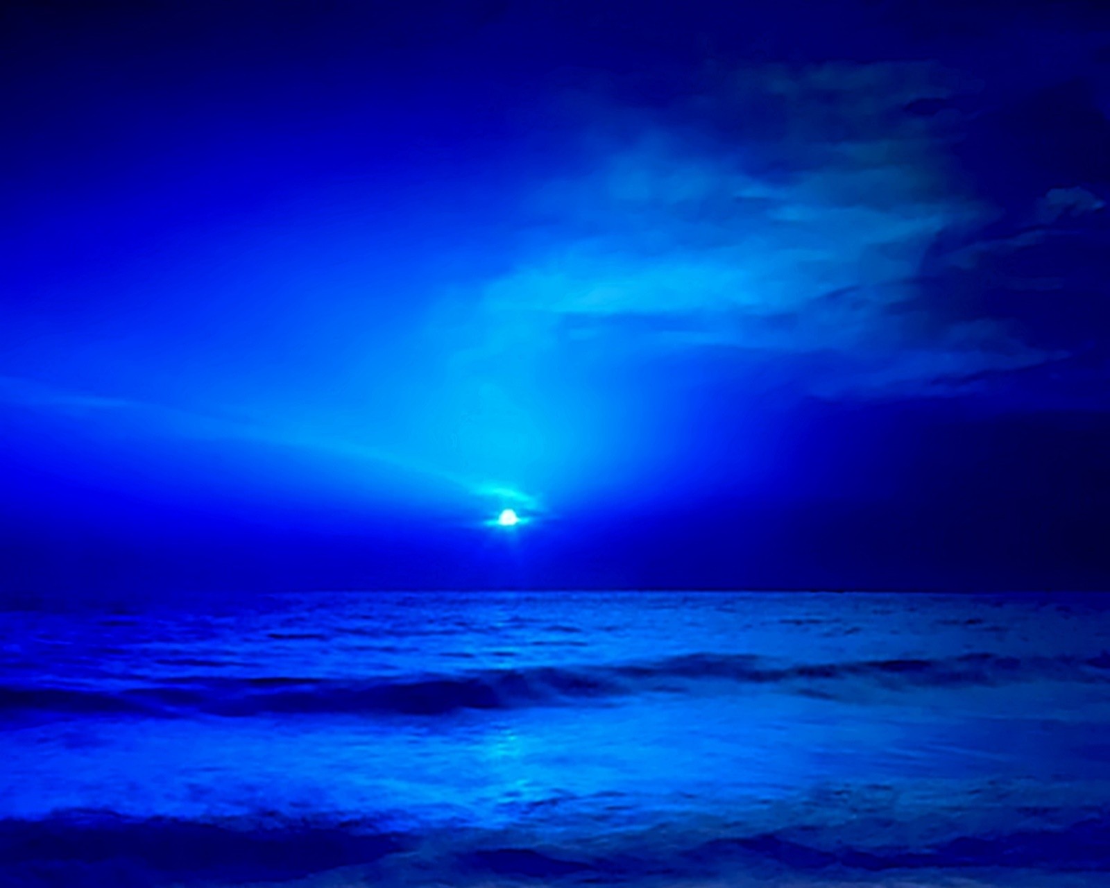 Arafed view of a blue ocean with a bright light shining through the clouds (blue, nature, sea)