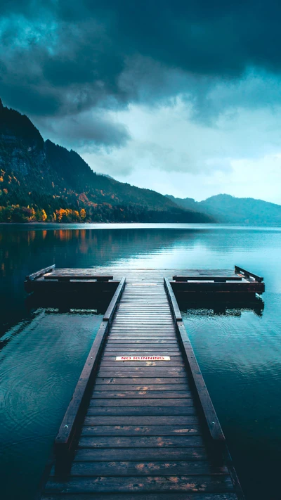 Tranquil Pier at Sunrise: A Dreamy Landscape of Mountains and Still Waters