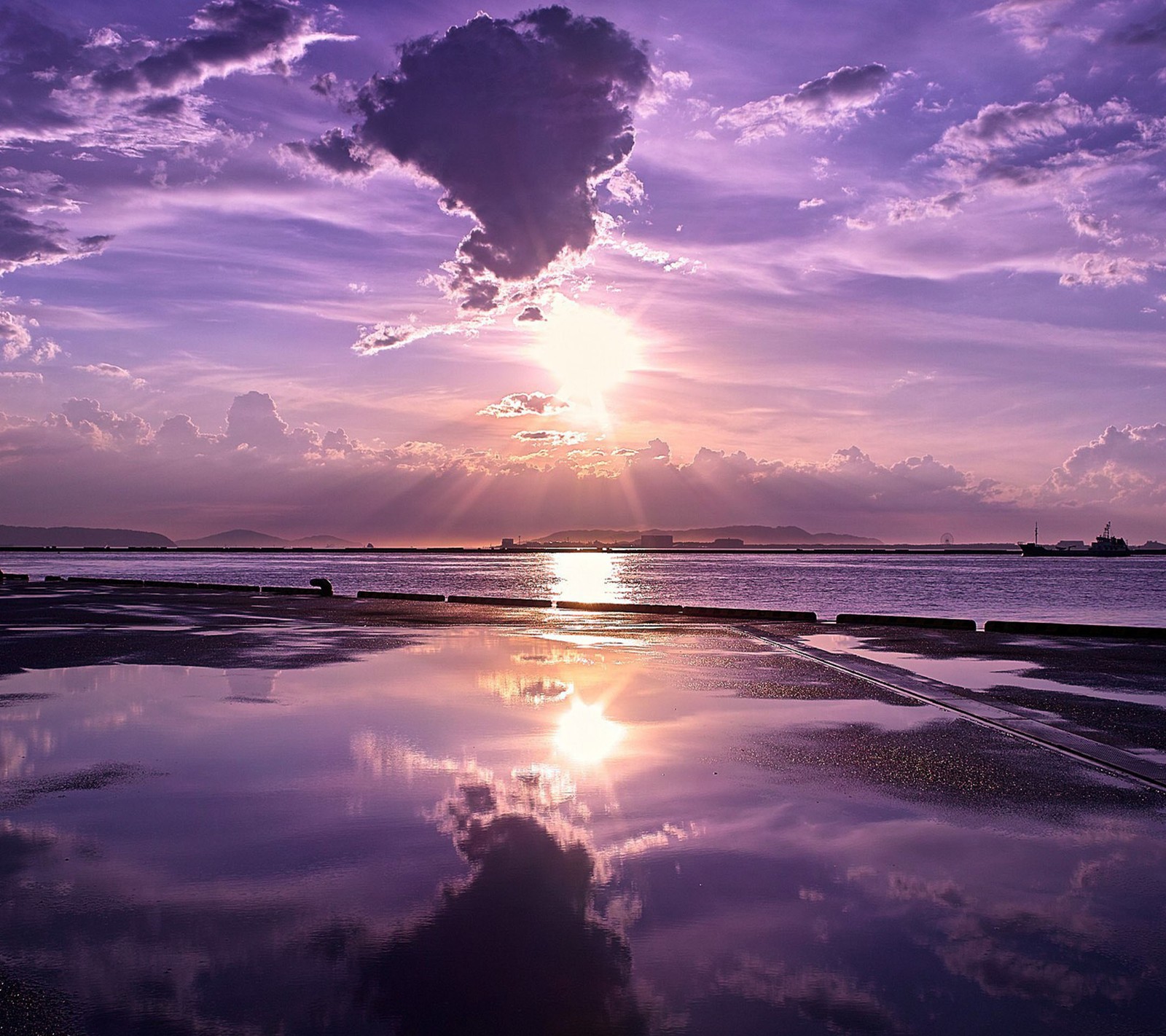 Purple sky with clouds reflecting in water and a person on a surfboard (rise, sun)