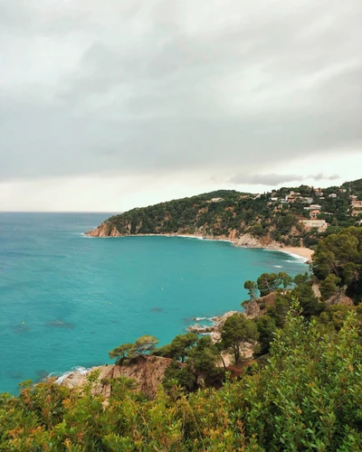 Küstenruhe: Eine malerische Aussicht auf türkisfarbenes Wasser und bergige Ufer