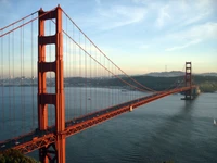 Golden Gate Bridge spanning the bay, framed by Twin Peaks under a clear sky.