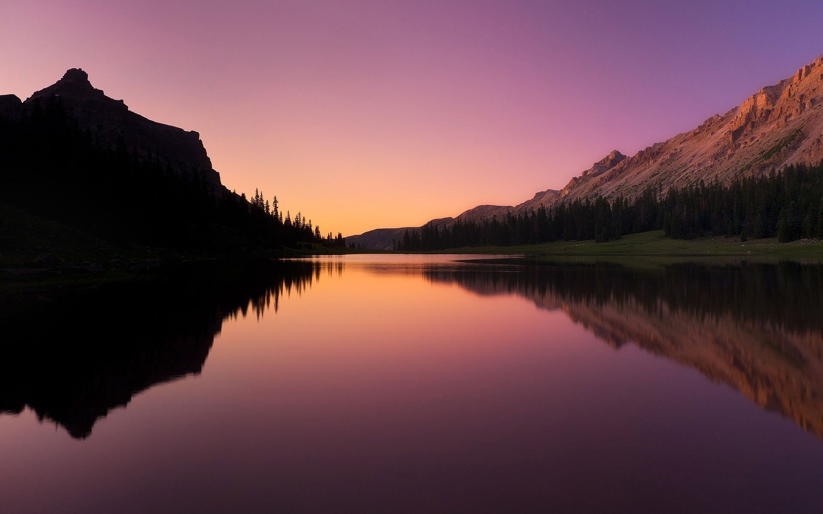 Uma vista árabe de uma cordilheira com um lago e um céu roxo (reflexo, natureza, água, wild, alvorada)