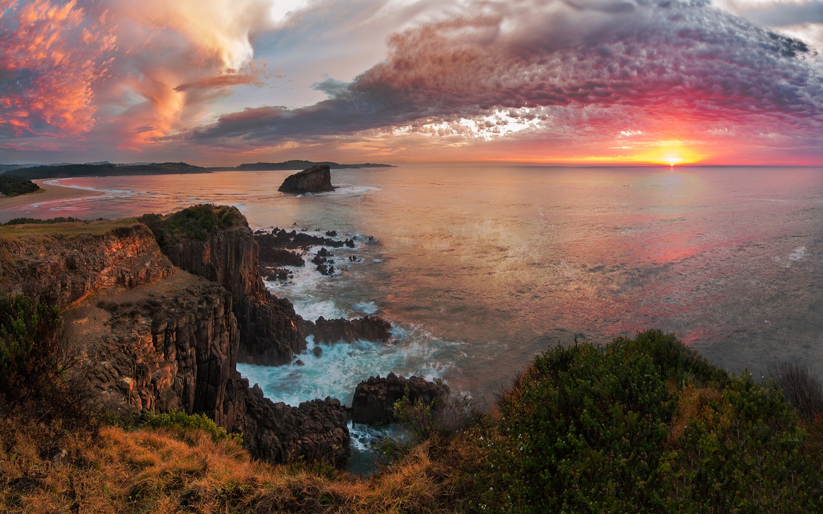 Una vista de un atardecer sobre el océano con un acantilado rocoso (atardecer, naturaleza, mar, costa, cabecera)