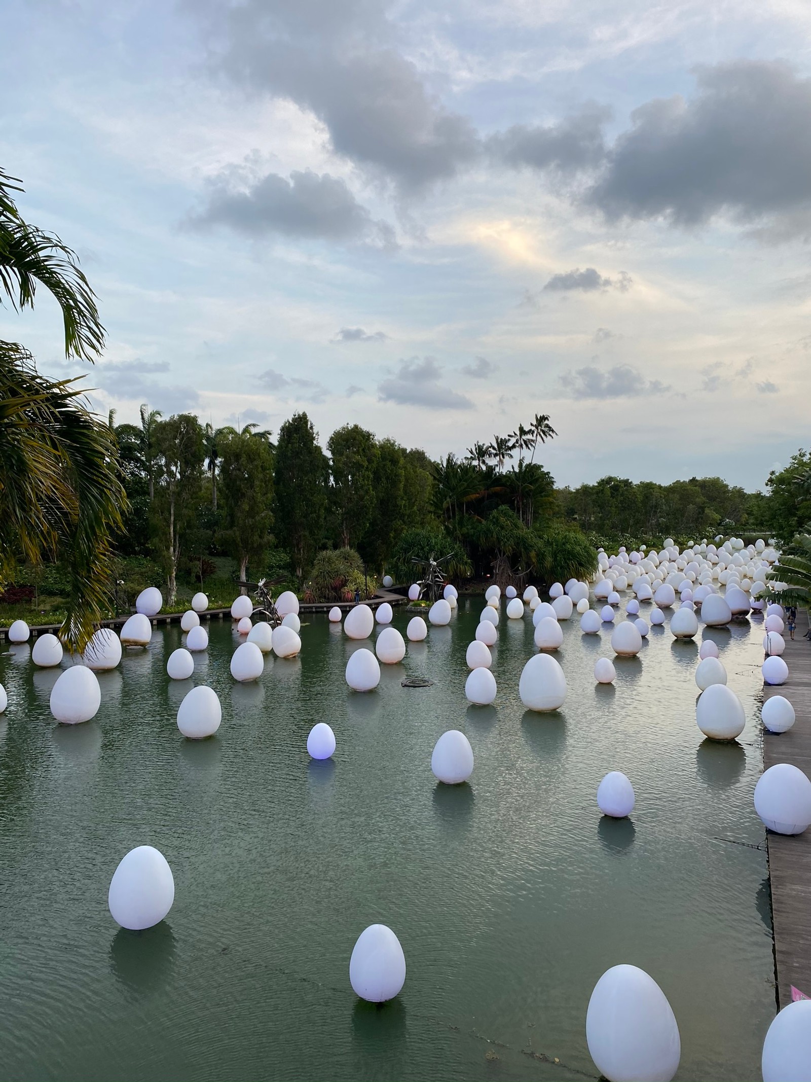 Il y a de nombreuses boules blanches flottant dans un étang d'eau (singapour, réflexion, ressources en eau, tourisme, eau)