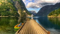 Fjord tranquilo con barco de crucero y reflejos escénicos de montañas