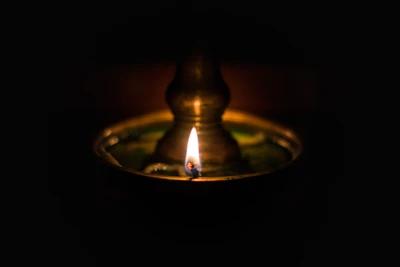 Glowing Flame of an Oil Lamp in Darkness