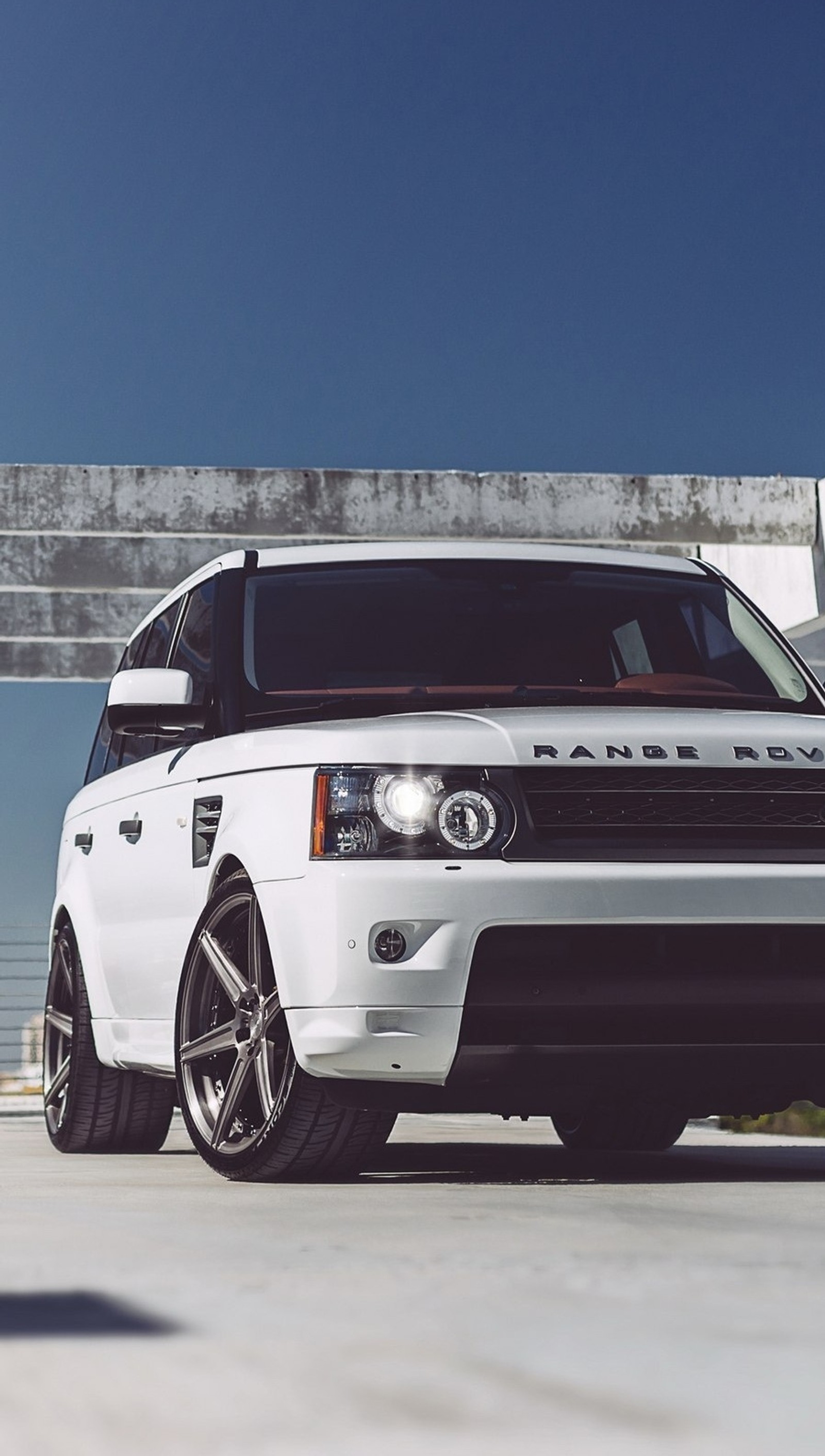 Un range rover blanc modifié garé devant un bâtiment (incroyable, voiture, rover, blanc)