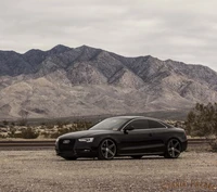 Audi S5 mit Vossen Rädern vor einer dramatischen Bergkulisse.