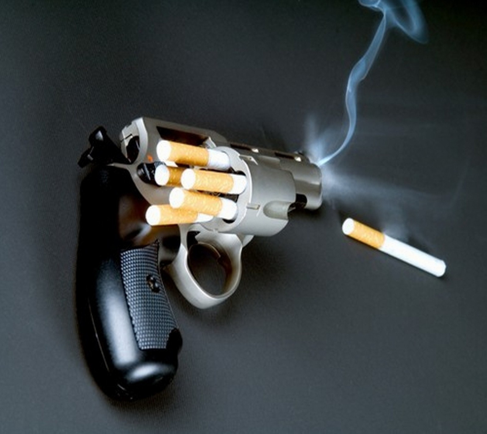 There is a gun with cigarettes and a mouse on the table (cigarette, dead, gun, shoot)