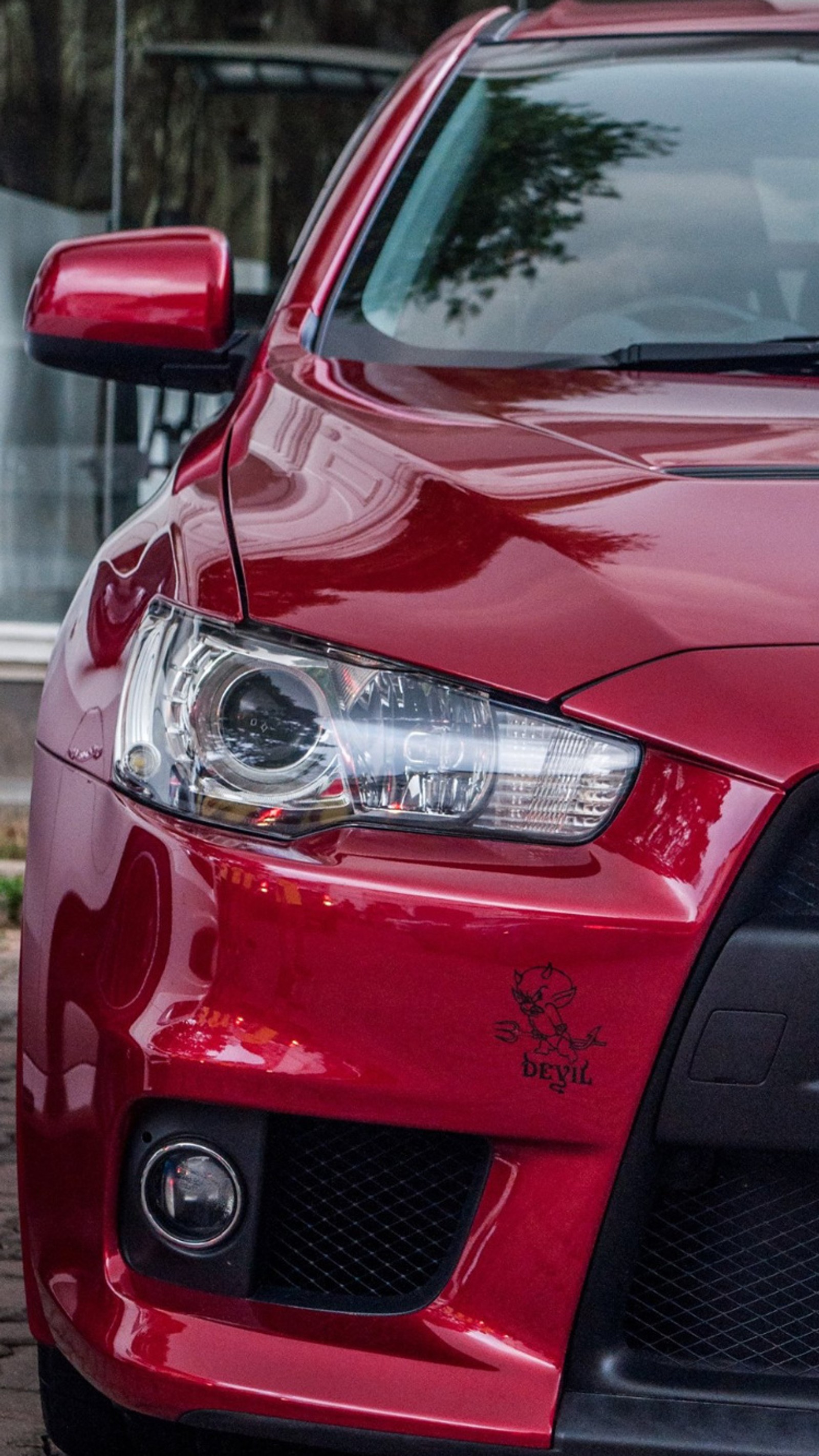 A close up of a red car parked on a street (car, lancer)