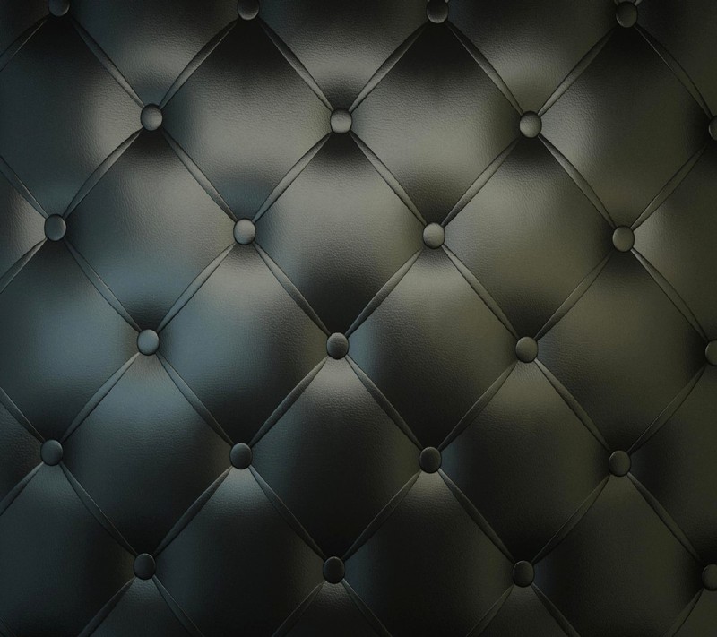 A close up of a black leather wall with a pattern (upholstered)